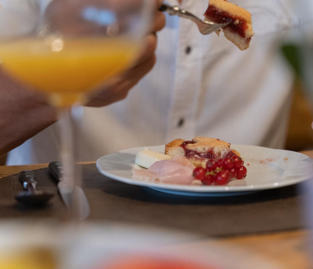 Elegant breakfast: dessert, fruit, and cheese on a refined plate.