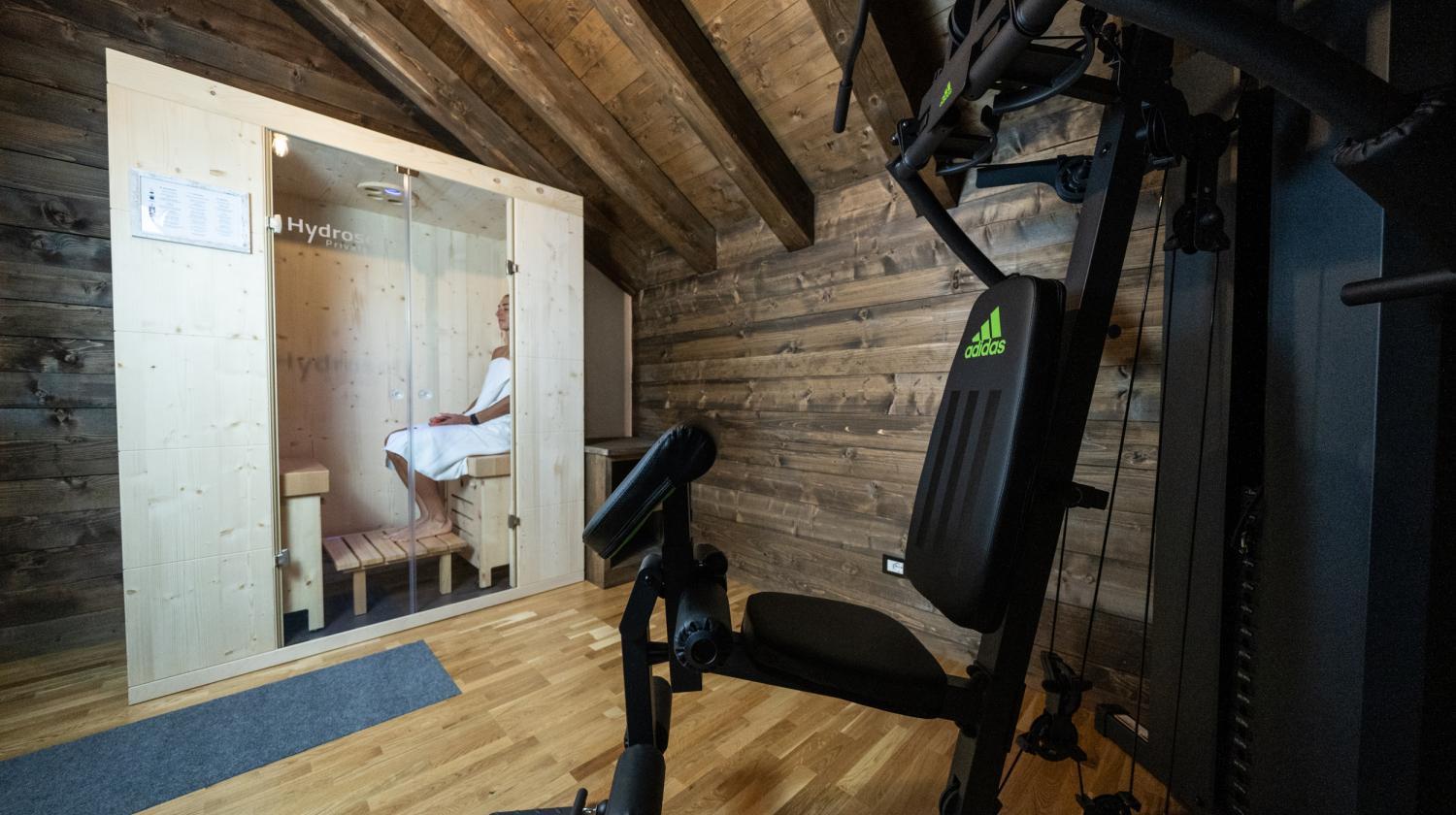 Una sauna accogliente accanto a una palestra in legno, calore e relax.