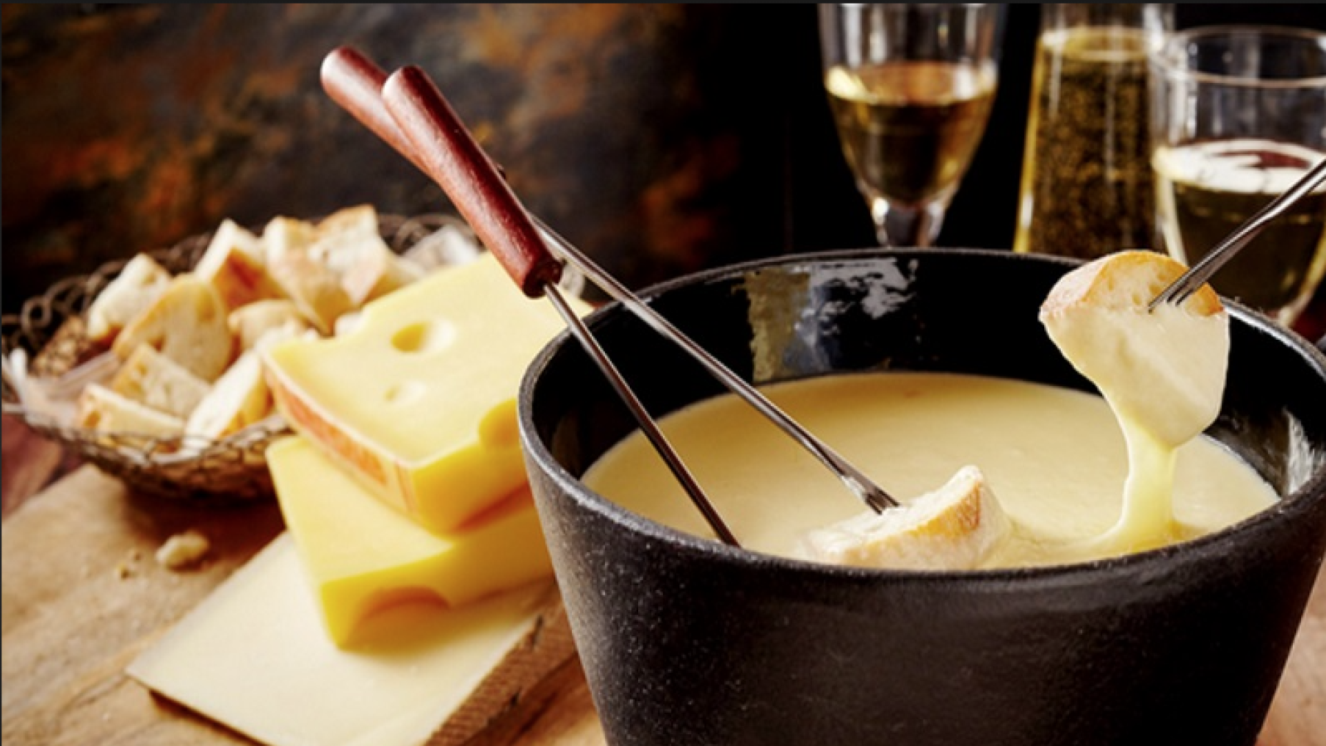 Fonduta di formaggio con pane e vino sul tavolo.