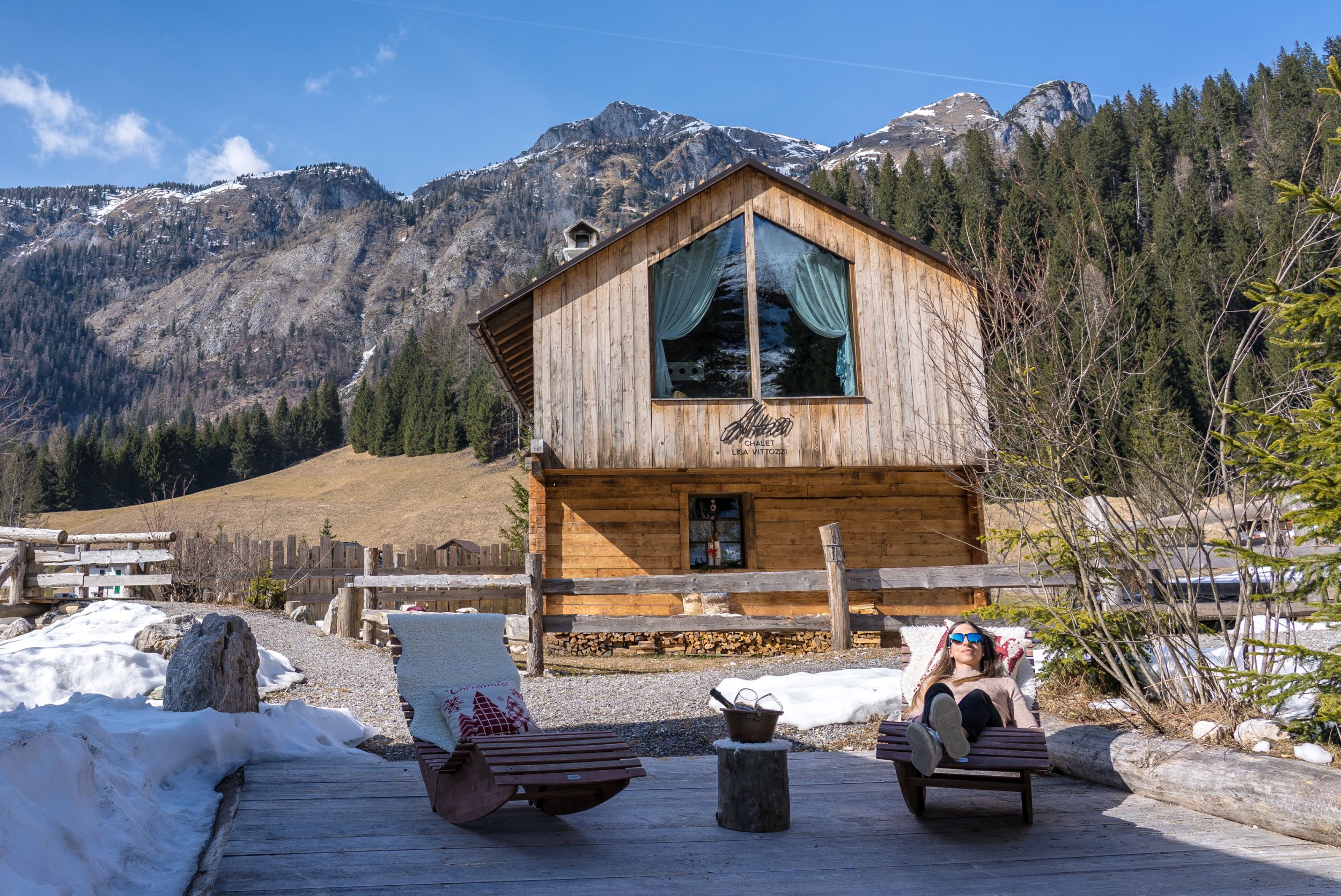 Chalet di montagna con sole, neve e relax tra le montagne.